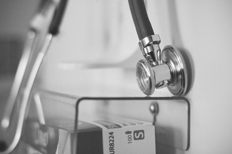 A stethoscope resting on a clinic wall rack